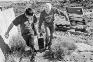 Paul Tso and Joseph Day haul an old battery off for proper disposal. A good portion of homes on Hopi do not have electricity and have relied on batteries and generators in the past, and, increasingly now, solar panels. © Tomas Muscionico